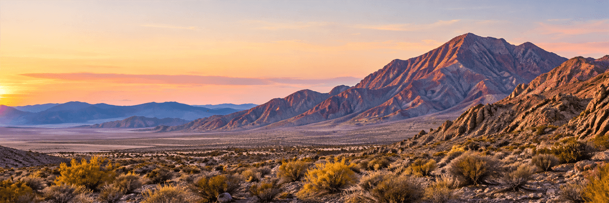 A sunlit Nevada desert landscape with red rock formations